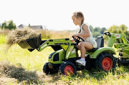 Un enfant sur un jouet Falk de l’univers « Les petits jardiniers »